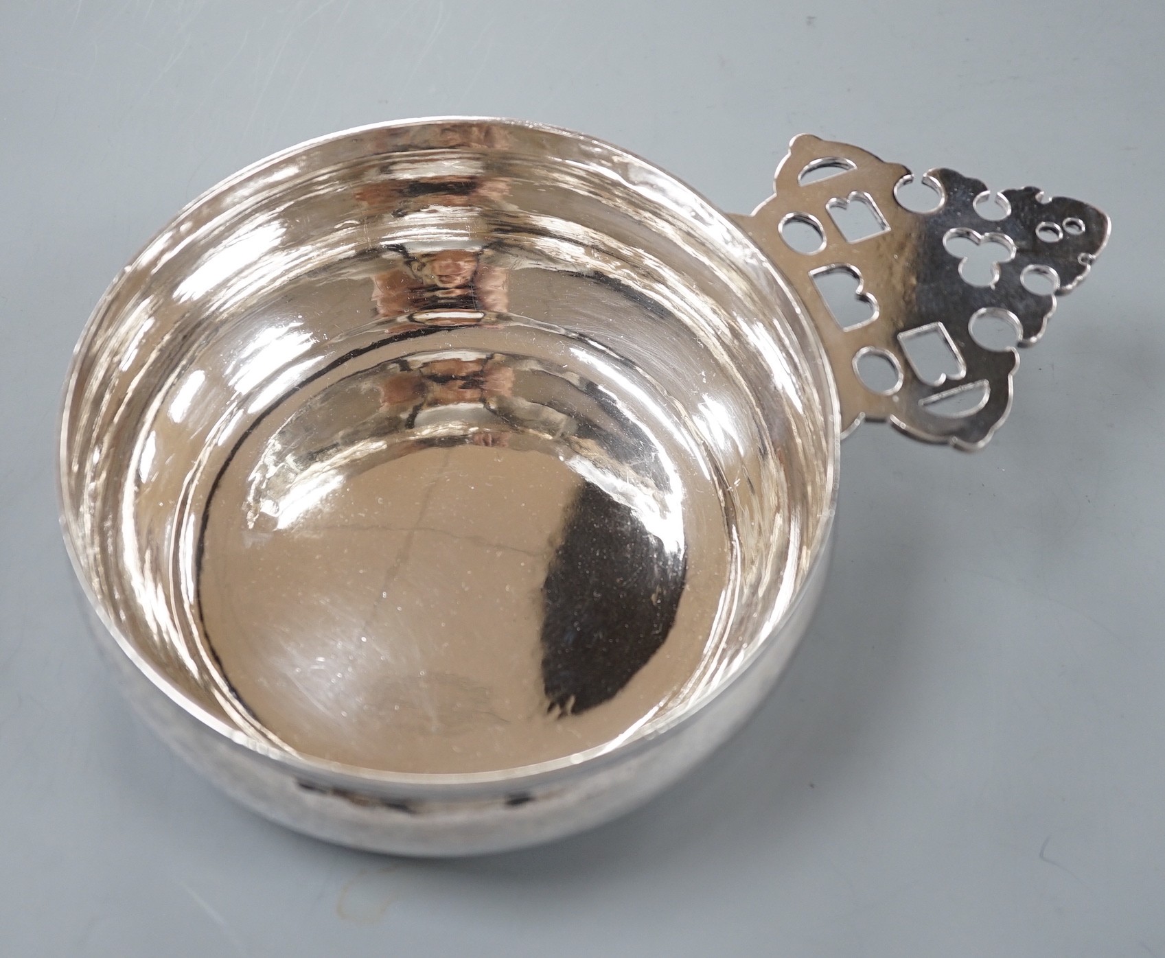A modern Brittania standard silver bleeding bowl, by Tessiers Ltd, with pierced handle, diameter including handle 19.5cm, 10.5oz.